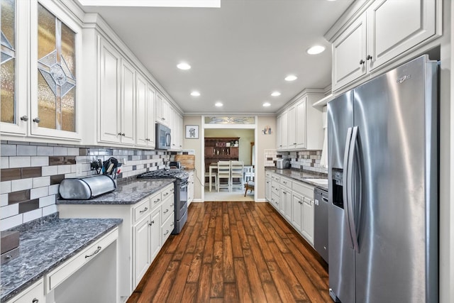 kitchen featuring glass insert cabinets, dark wood finished floors, decorative backsplash, appliances with stainless steel finishes, and white cabinetry