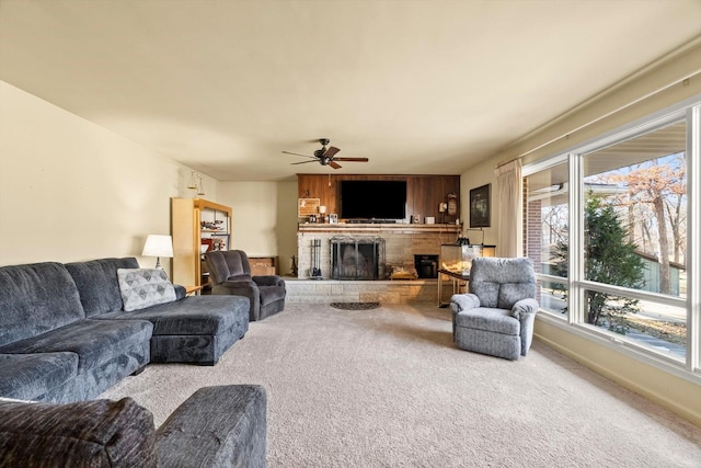 carpeted living room featuring a fireplace with raised hearth, baseboards, and ceiling fan