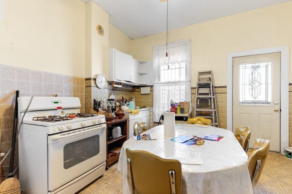 2016 W Superior St, Chicago, IL 60612 - kitchen featuring white range with gas cooktop, plenty of natural light, tile walls, and light tile patterned floors