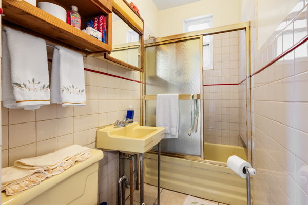 2016 W Superior St, Chicago, IL 60612 - bathroom featuring a sink, toilet, tile walls, tile patterned flooring, and enclosed tub / shower combo