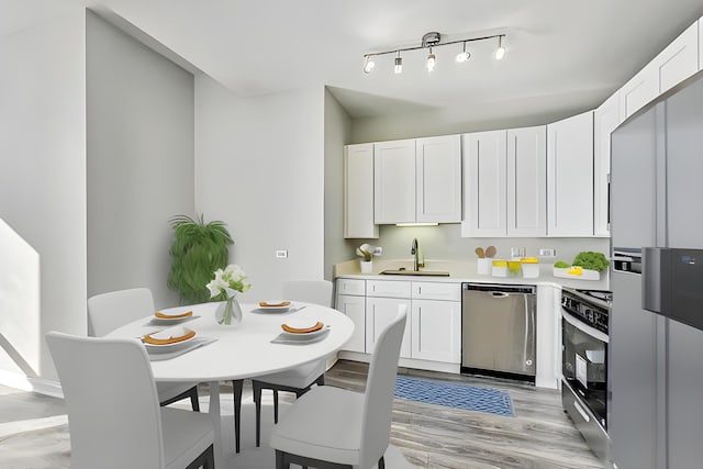 kitchen with white cabinets, appliances with stainless steel finishes, light countertops, and a sink