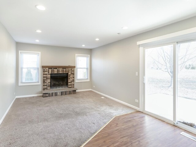 unfurnished living room featuring recessed lighting, visible vents, a healthy amount of sunlight, and baseboards