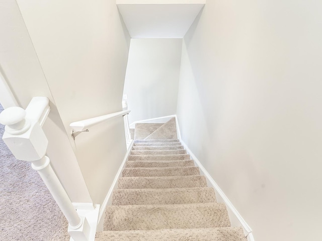 staircase with baseboards and carpet flooring