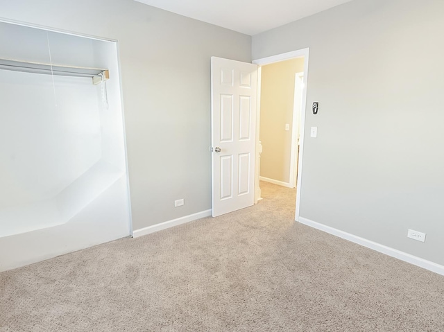 unfurnished bedroom with carpet, baseboards, and a closet