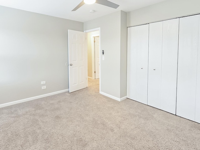 unfurnished bedroom with a closet, carpet floors, baseboards, and a ceiling fan