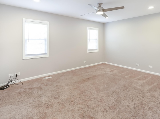 spare room with visible vents, carpet floors, baseboards, and ceiling fan