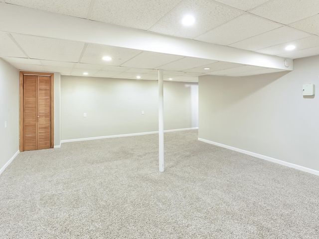 finished below grade area featuring a drop ceiling, recessed lighting, carpet, and baseboards