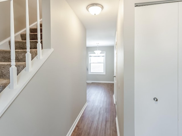 hallway with stairs, baseboards, and wood finished floors