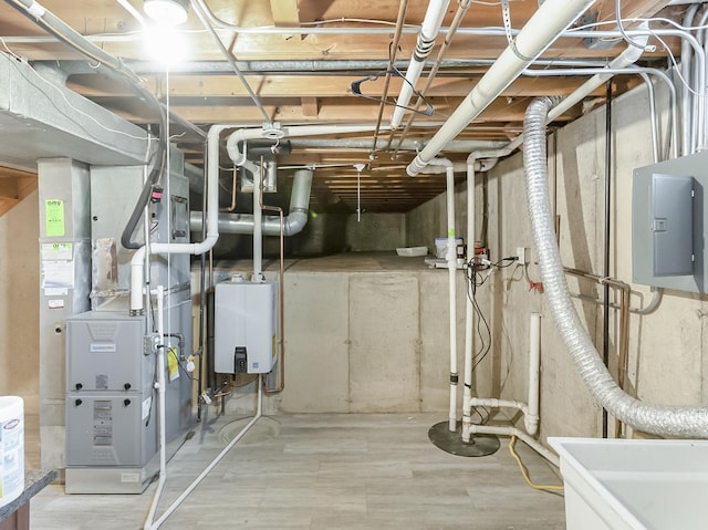 utility room featuring electric panel, heating unit, water heater, and a sink