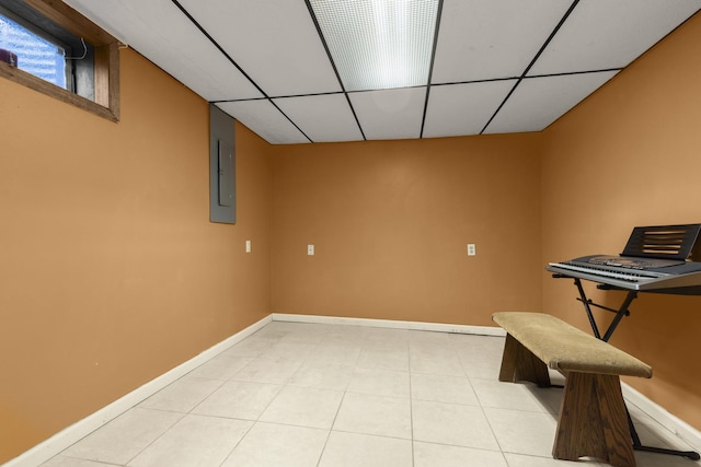 interior space featuring electric panel, a paneled ceiling, baseboards, and light tile patterned floors