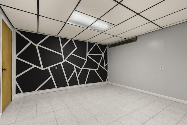 spare room with a drop ceiling and baseboards