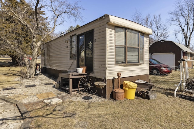 view of side of home featuring an outdoor structure and fence