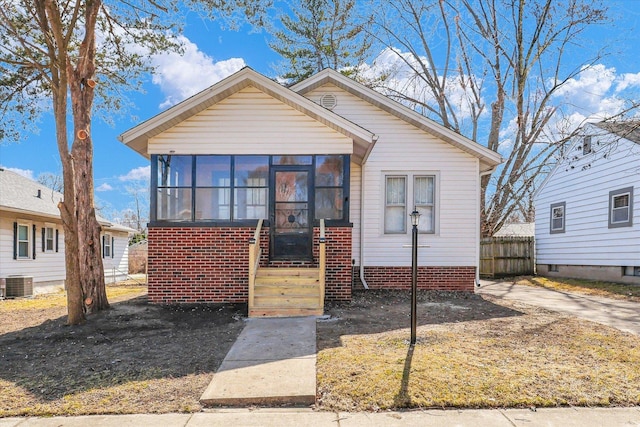 bungalow-style home featuring central AC unit, fence, and a sunroom