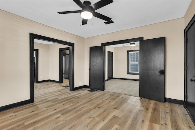 spare room featuring visible vents, baseboards, light wood finished floors, and ceiling fan