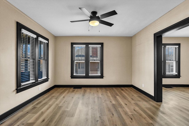 unfurnished room with a ceiling fan, baseboards, and wood finished floors