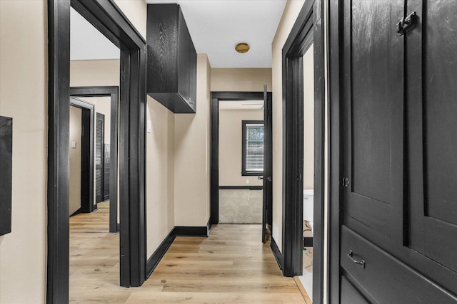 hallway with light wood-style floors and baseboards