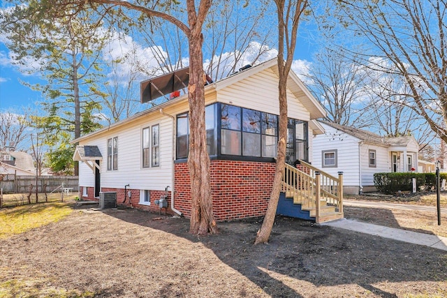 exterior space featuring a sunroom, fence, and central AC