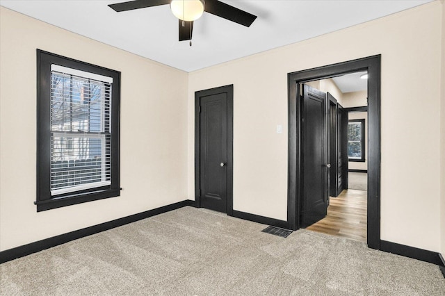 unfurnished room with carpet flooring, ceiling fan, visible vents, and baseboards