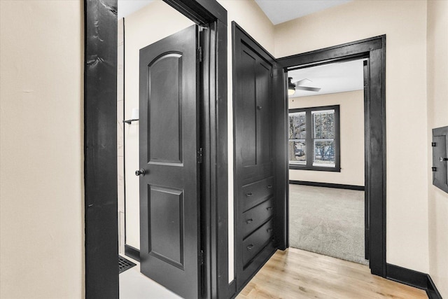 hall with baseboards and light wood-style floors