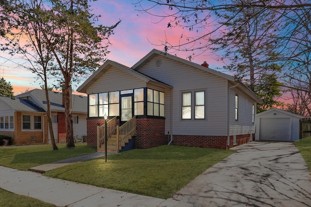 bungalow featuring a garage, a front lawn, an outbuilding, and driveway