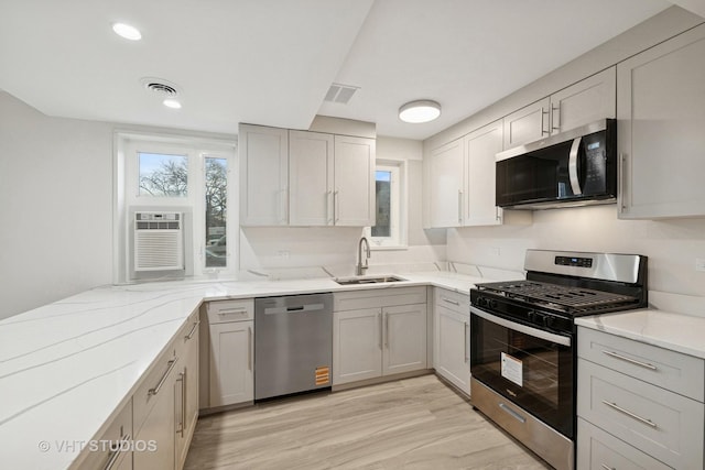 7202 Oak Ave Unit 1Ne, River Forest, IL 60305 - kitchen with appliances with stainless steel finishes, a sink, light stone countertops, light wood finished floors, and gray cabinets