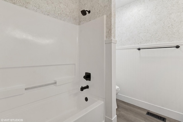 full bath with a wainscoted wall, visible vents, toilet, wood finished floors, and wallpapered walls