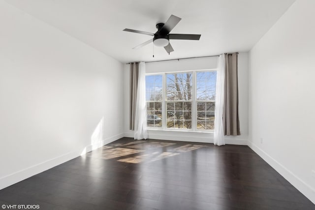 unfurnished room with baseboards, a ceiling fan, and wood finished floors