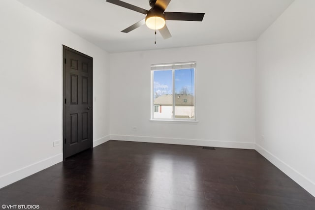 empty room with visible vents, baseboards, dark wood-style flooring, and ceiling fan