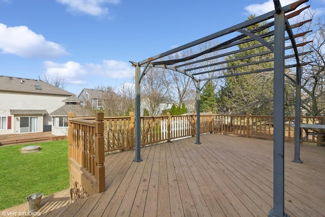 wooden deck with a lawn and a pergola