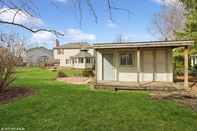 back of property featuring a gazebo, a yard, and an outbuilding