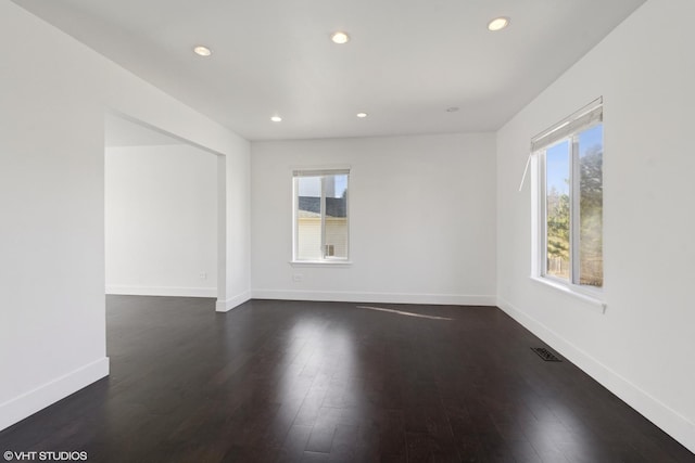 empty room featuring dark wood finished floors, recessed lighting, and baseboards