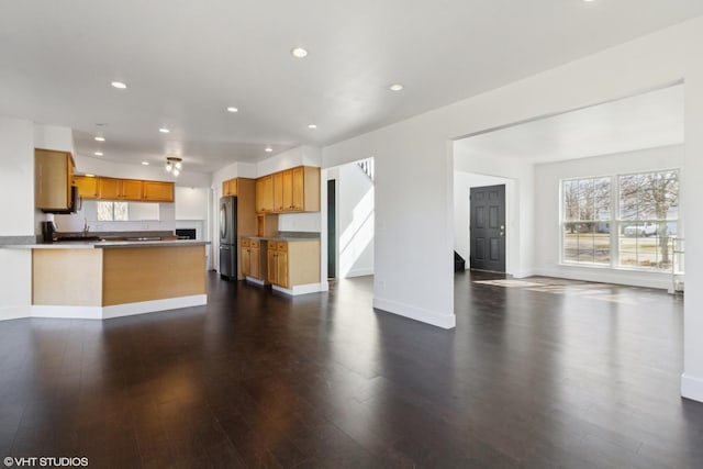 kitchen with recessed lighting, dark wood-style floors, open floor plan, and freestanding refrigerator