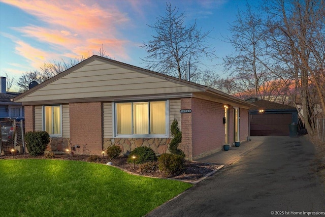 16340 Justine St, Markham, IL 60428 - property exterior at dusk featuring brick siding, a detached garage, a lawn, and an outbuilding