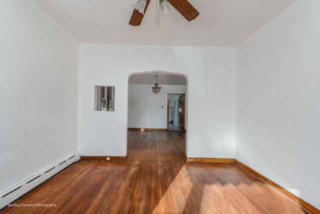 spare room with arched walkways, wood-type flooring, baseboards, baseboard heating, and ceiling fan