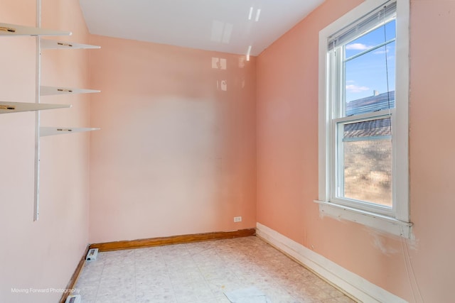 unfurnished room featuring baseboards and light floors