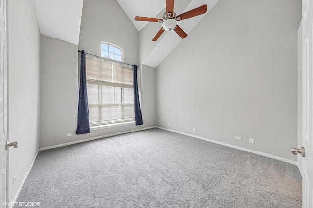 carpeted spare room featuring baseboards, high vaulted ceiling, and ceiling fan
