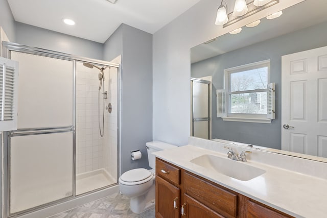 bathroom with vanity, toilet, and a stall shower