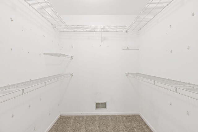 walk in closet with visible vents and carpet