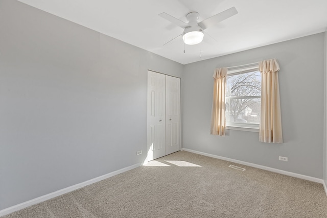 unfurnished bedroom with visible vents, baseboards, carpet flooring, a closet, and a ceiling fan