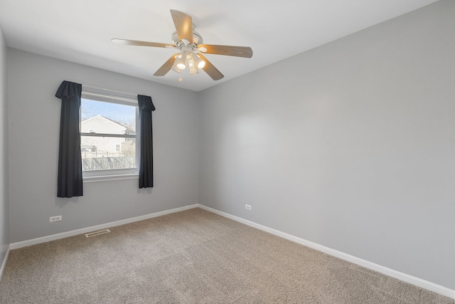 unfurnished room with visible vents, ceiling fan, carpet, and baseboards