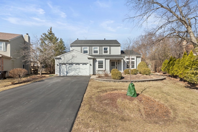 traditional-style home featuring an attached garage and driveway