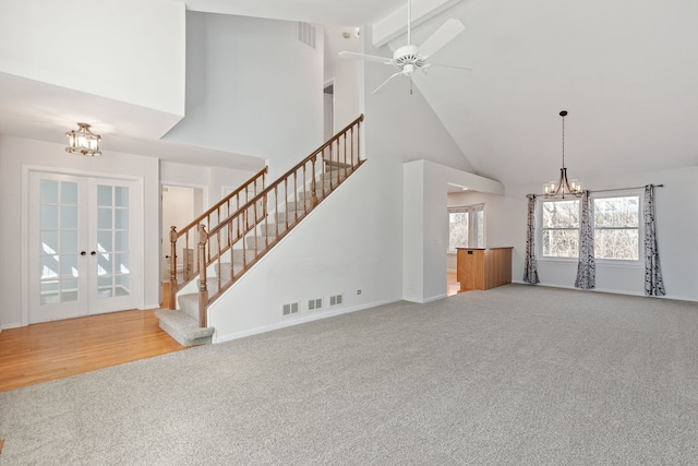 unfurnished living room with french doors, stairs, and carpet floors