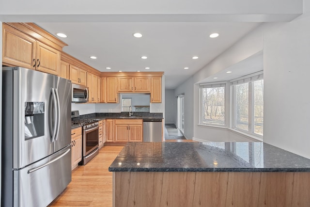 kitchen with light brown cabinets, a sink, recessed lighting, light wood-style floors, and appliances with stainless steel finishes