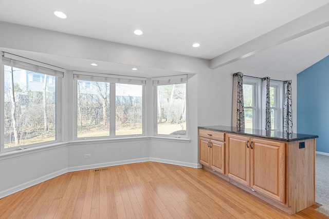 kitchen featuring visible vents, recessed lighting, dark stone counters, light wood finished floors, and baseboards