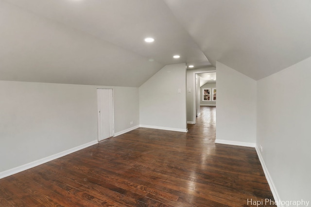 additional living space with lofted ceiling, wood finished floors, baseboards, and recessed lighting