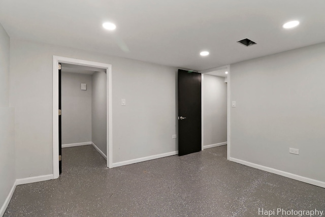 empty room featuring baseboards and recessed lighting
