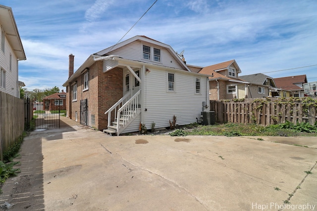 back of property with fence, a residential view, and brick siding