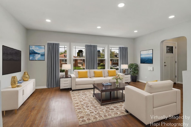 living room with arched walkways, baseboards, wood finished floors, and recessed lighting