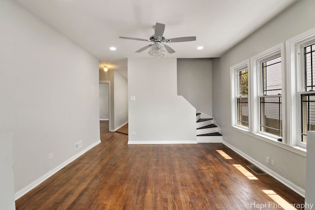 unfurnished room featuring ceiling fan, recessed lighting, baseboards, wood finished floors, and stairs