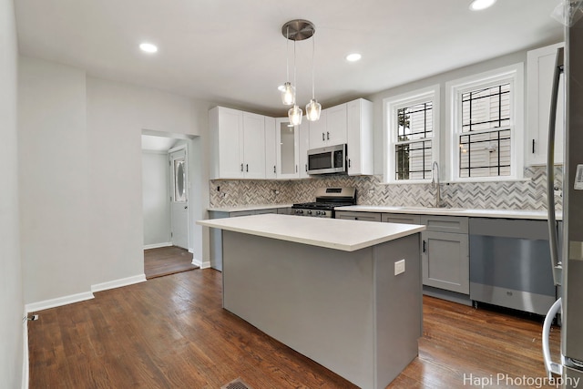 kitchen featuring stainless steel appliances, a sink, backsplash, glass insert cabinets, and recessed lighting